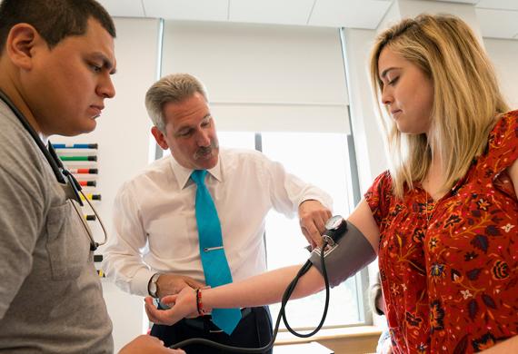 An image of faculty member demonstrating use of medical equipment during class.